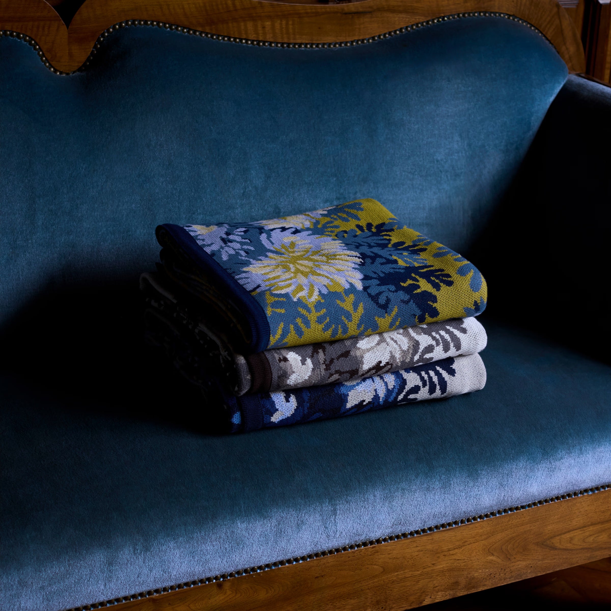 Stack of folded patterned towels on a blue cushioned chair