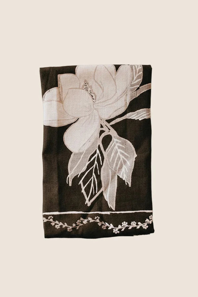 Black towel with white floral design on a beige background