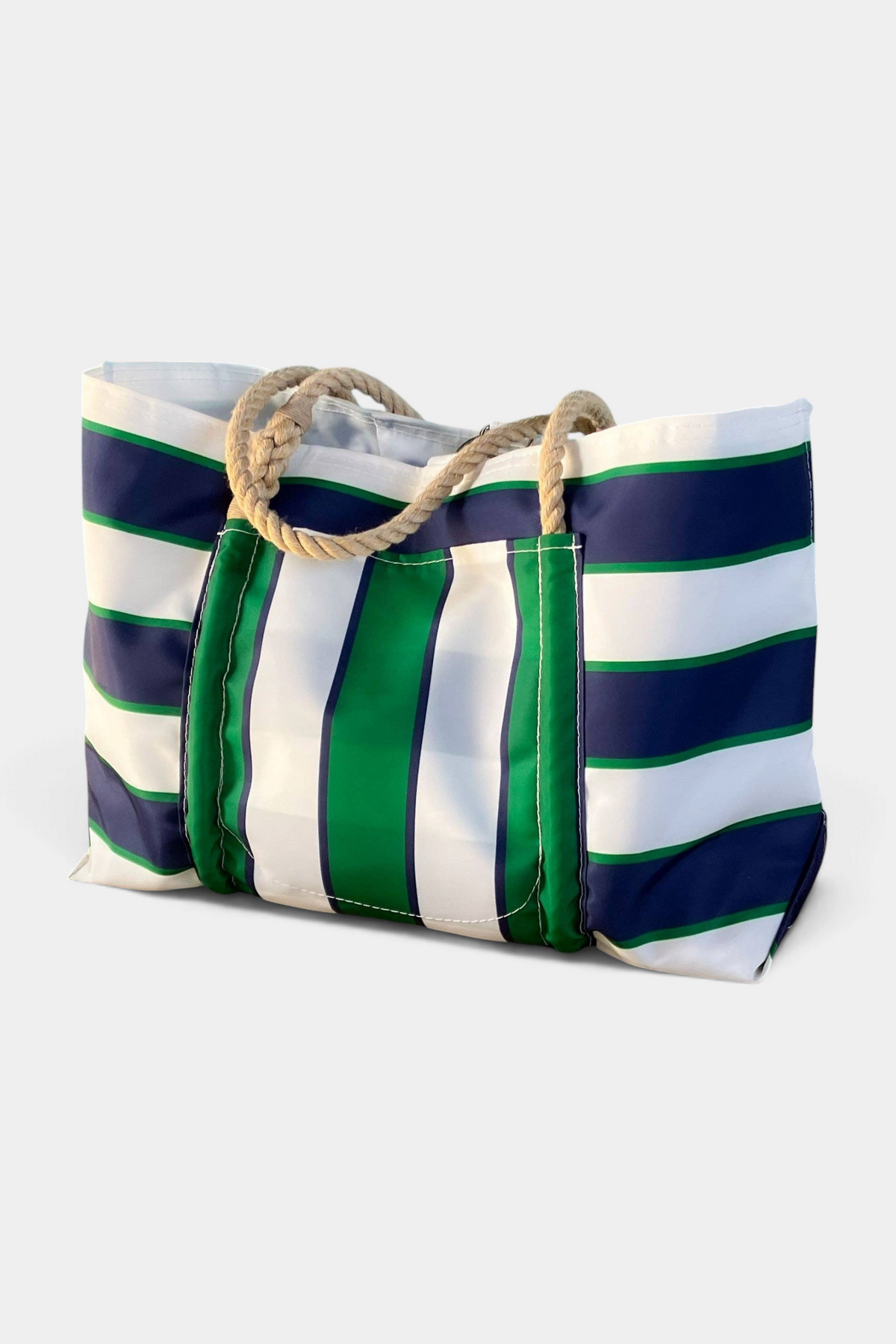 Striped bag with green, white, and navy colors on a poolside.