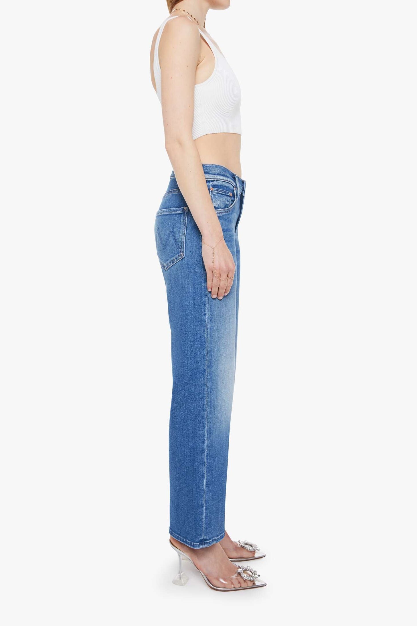 Woman wearing blue jeans and a white top on a white background