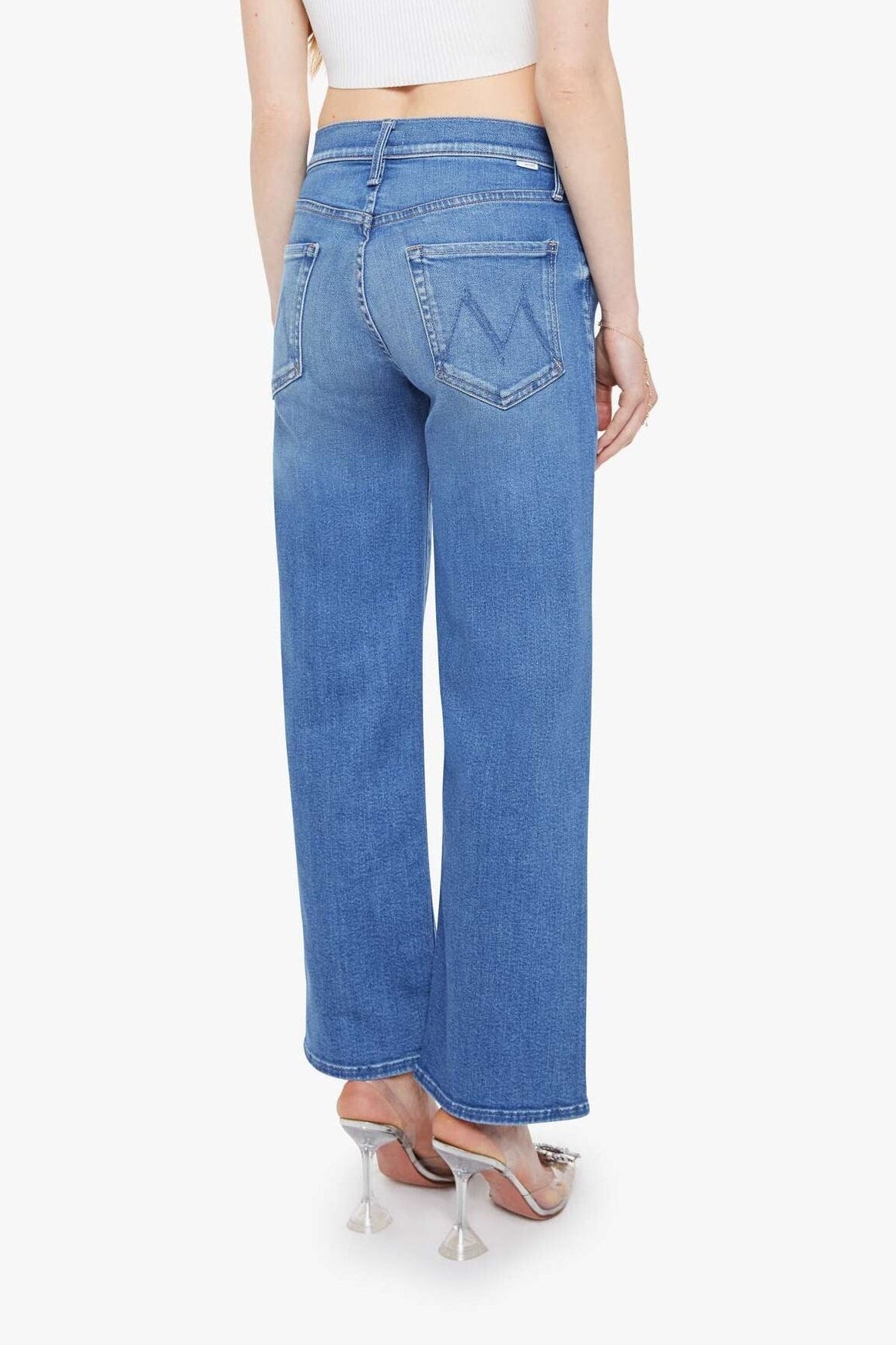 Woman wearing blue jeans and a white top on a white background