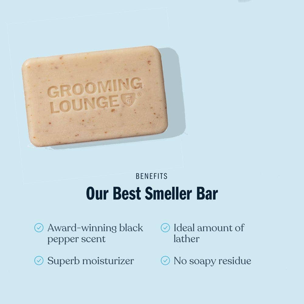 Bar of soap from Grooming Lounge on a light blue background with text listing benefits.