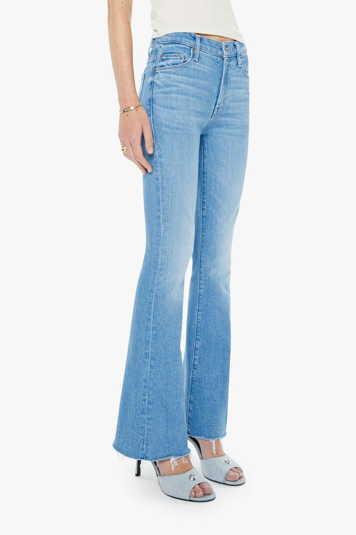 Woman wearing a white top and light blue jeans on a white background