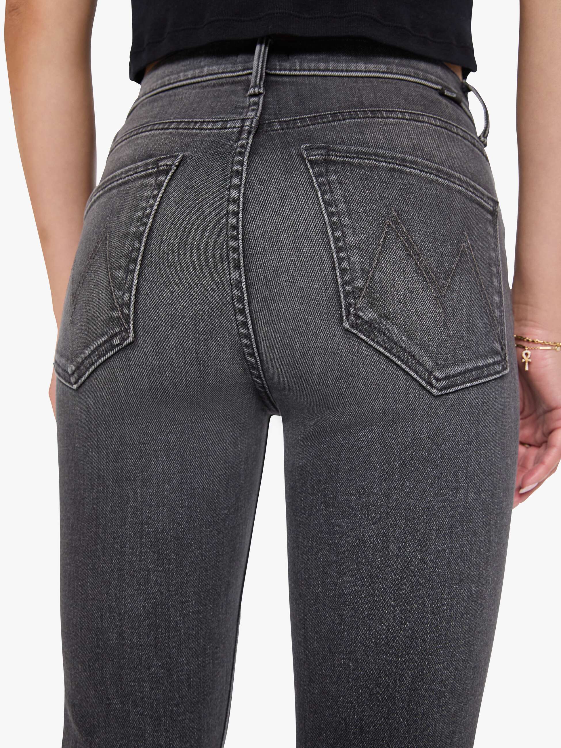 Gray jeans being worn on a plain background