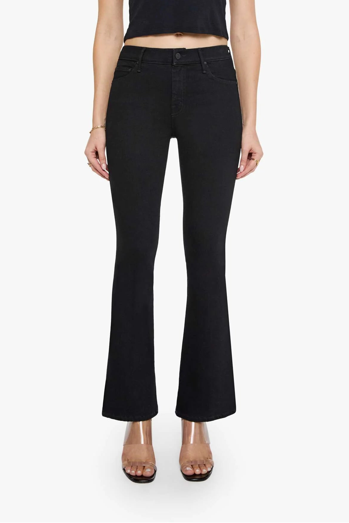 Woman wearing a black crop top and black flared pants on a white background