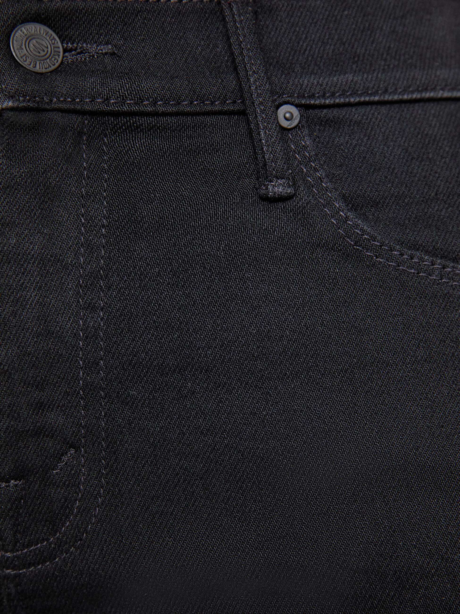 Close-up of black denim fabric with stitching details