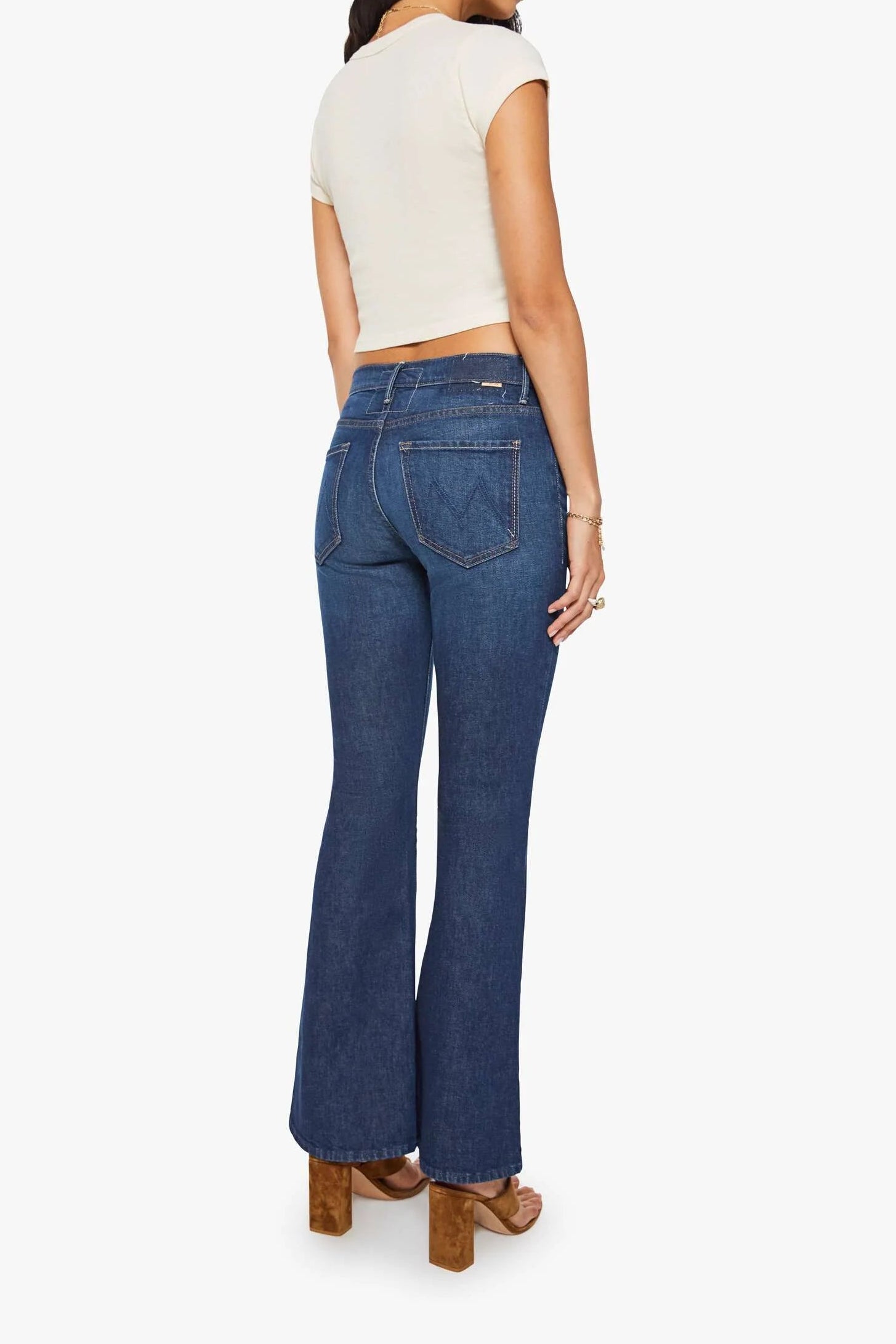 Woman wearing blue jeans and a white top on a white background