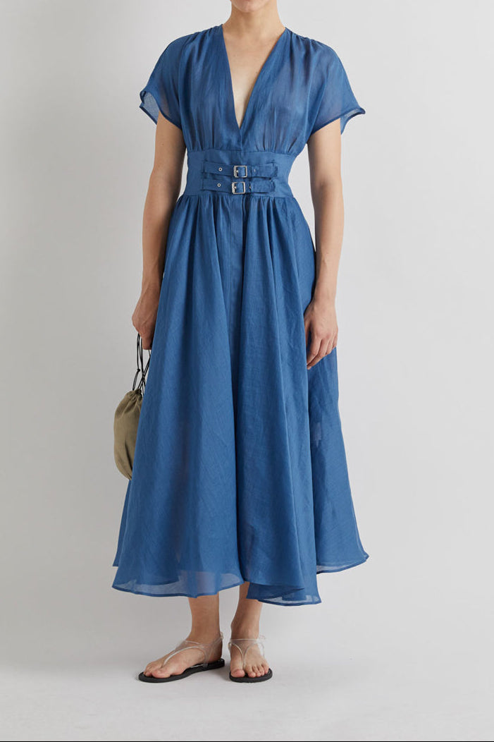 Woman wearing a blue dress on a plain background