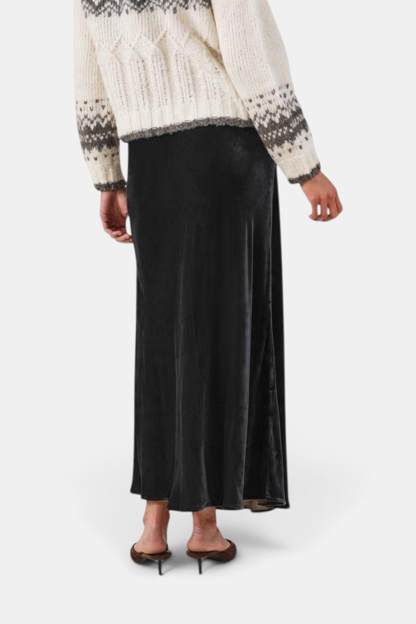The Copper Shed black velvet maxi skirt with an A-line silhouette and elastic waist, shown from the back.