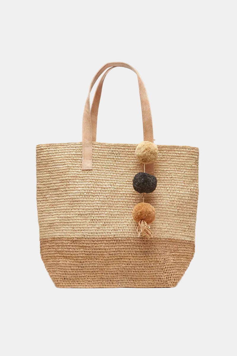 Woven tote bag with pom-pom details on a white background