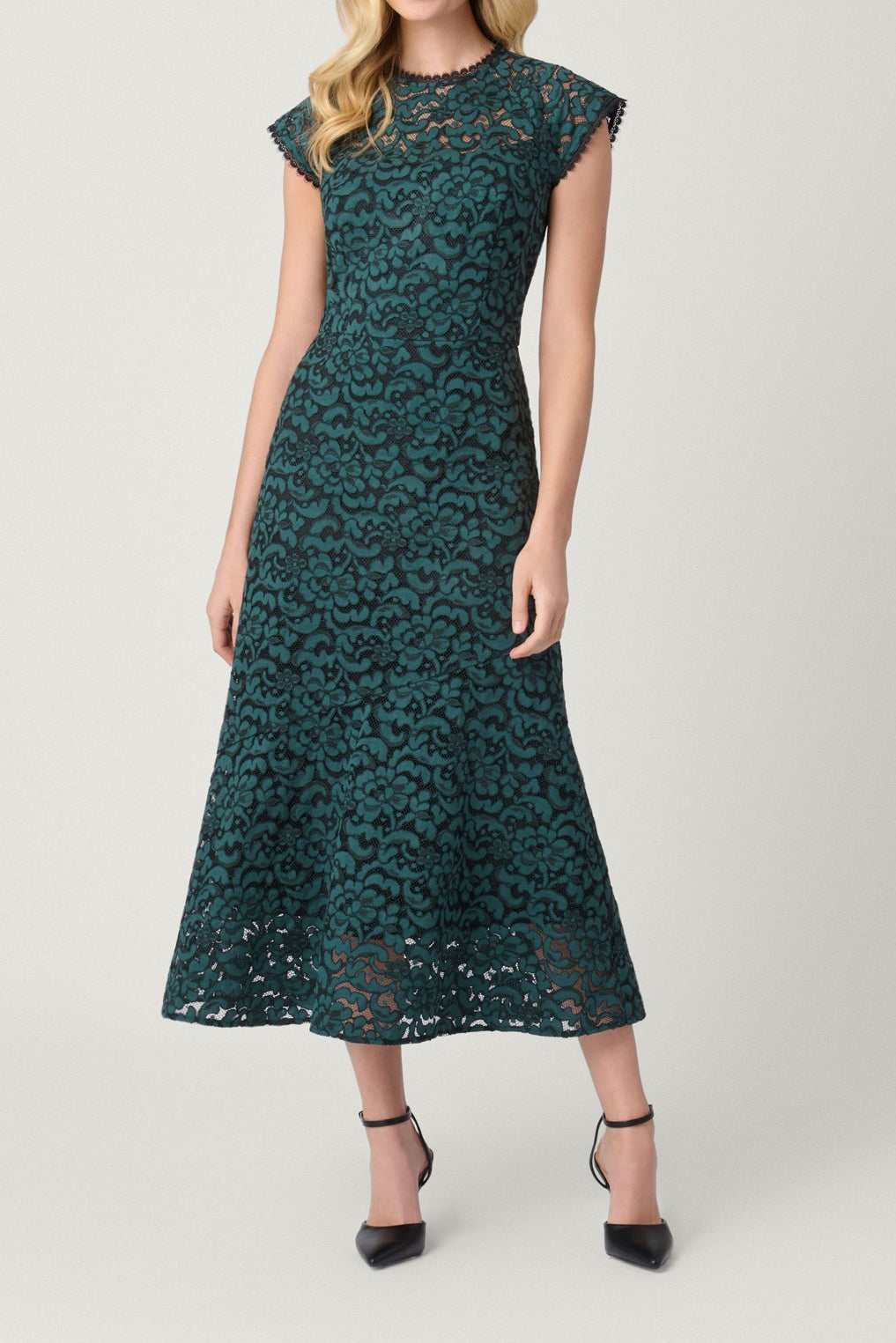 Woman wearing a teal lace dress on a white background
