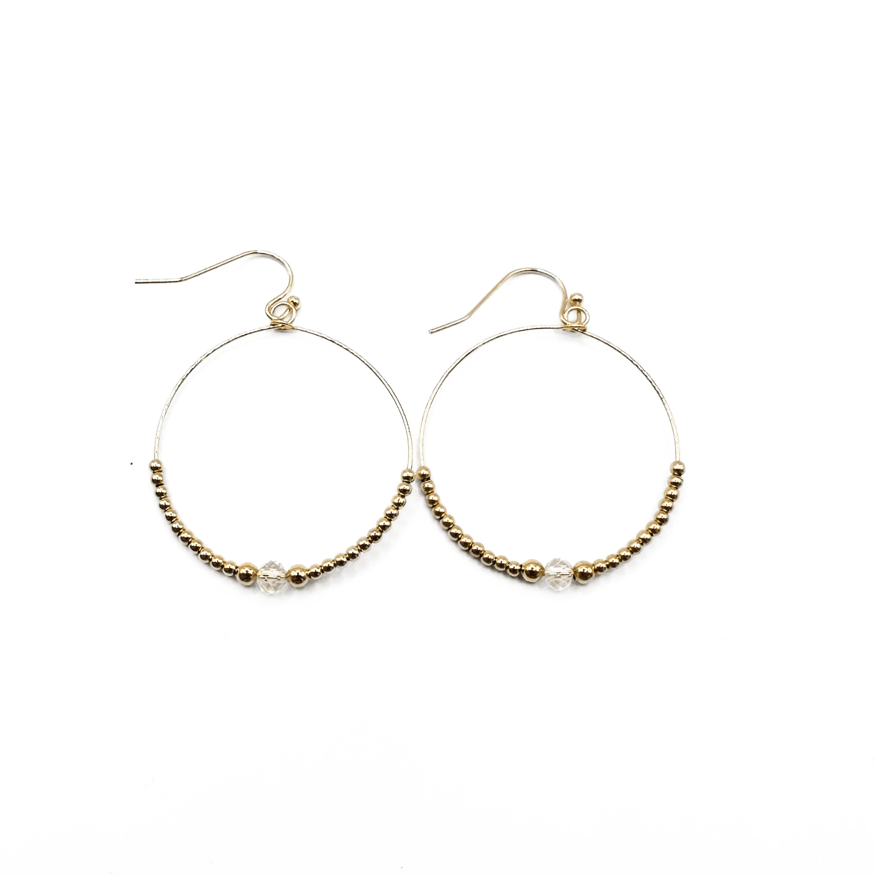 Gold hoop earrings with beaded accents on a white background