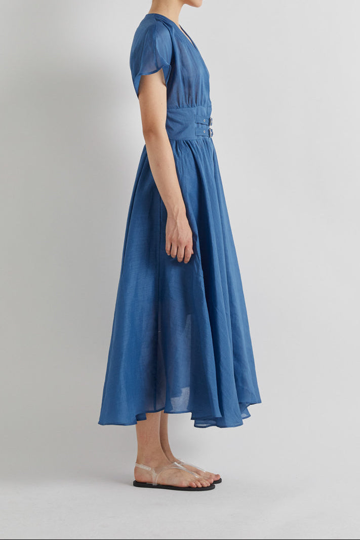 Woman wearing a blue dress on a plain background