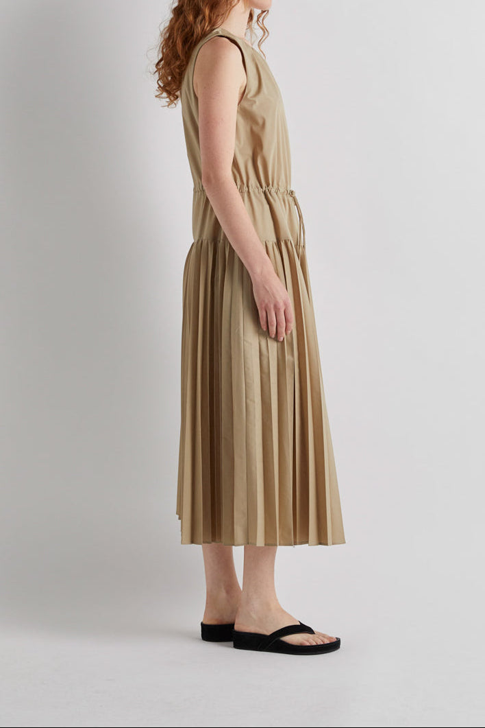 Woman wearing a beige dress against a white background