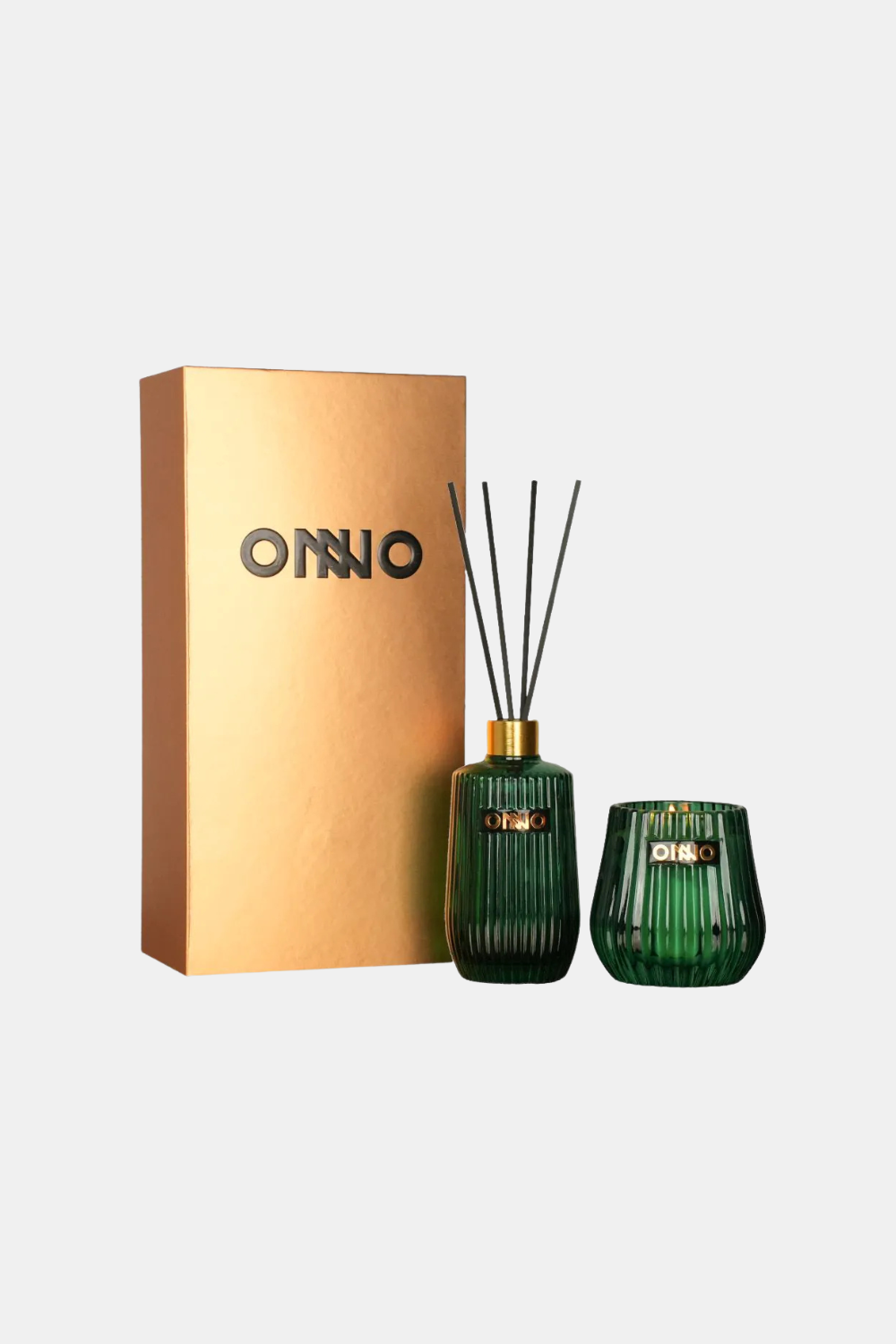 A reed diffuser set with a gold metallic box, a ribbed green glass bottle with reeds, and a matching green glass cup, all on a light gray background. The brand name 'ONNO' is visible on the packaging and the cup.