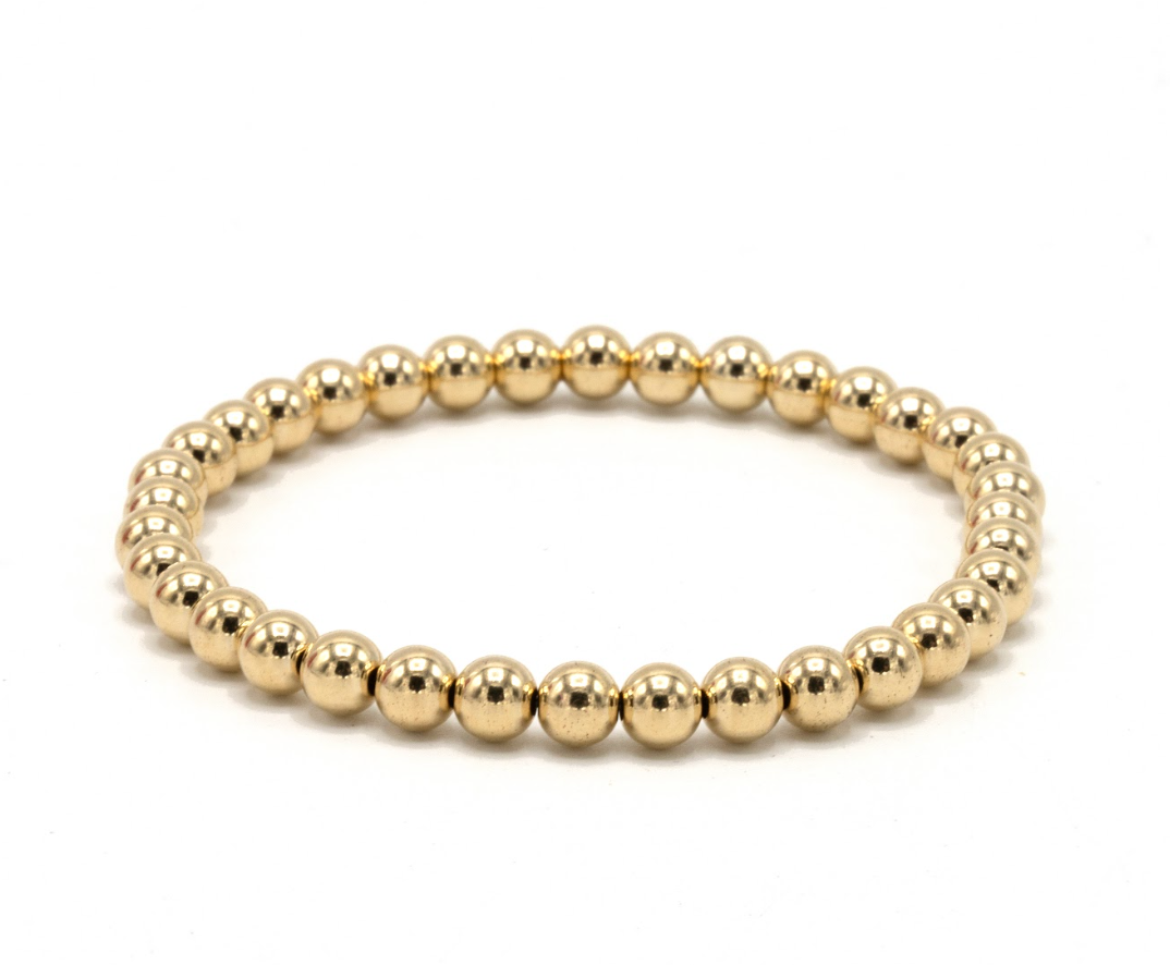 Gold beaded bracelet on a white background