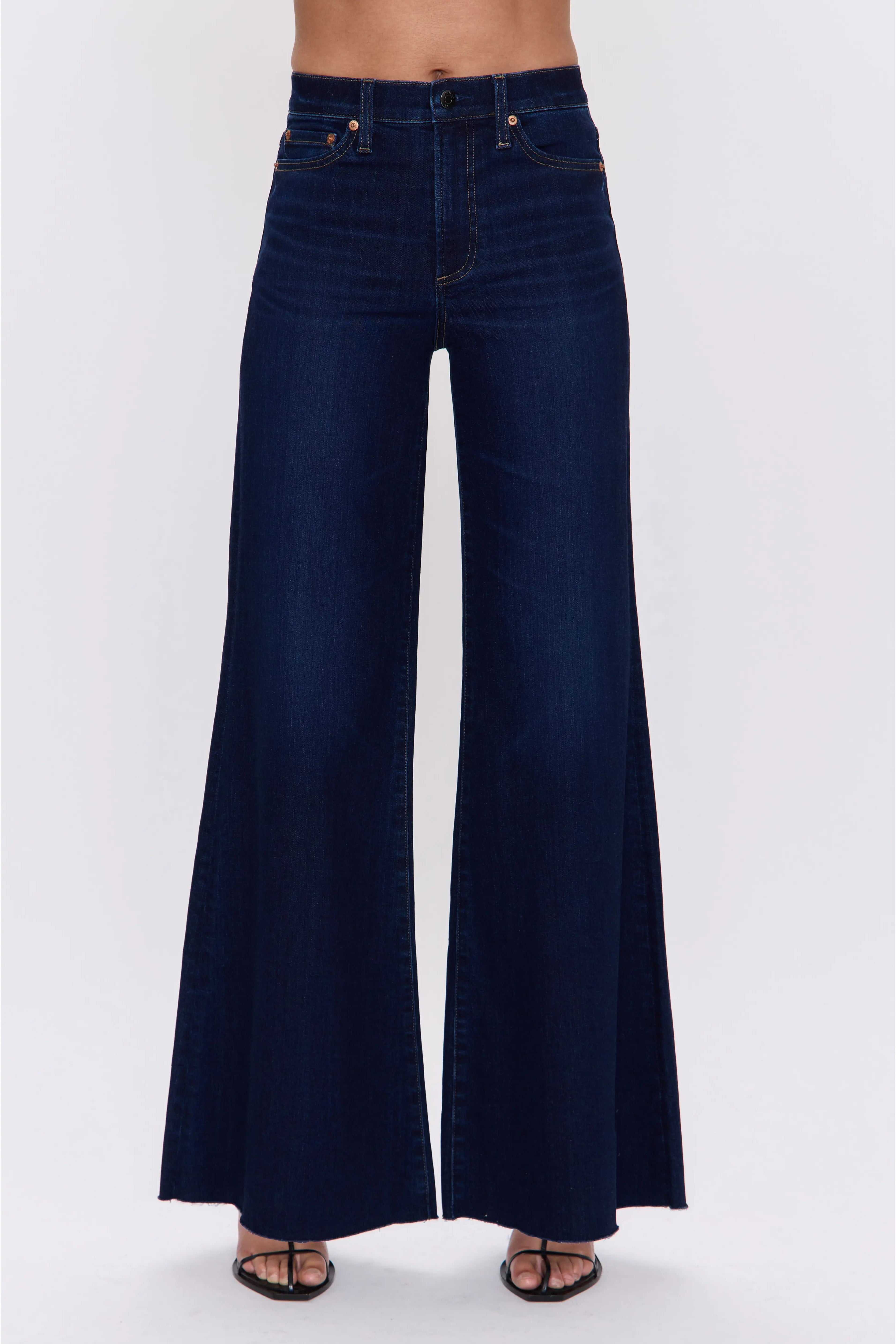 Dark blue flared jeans on a white background