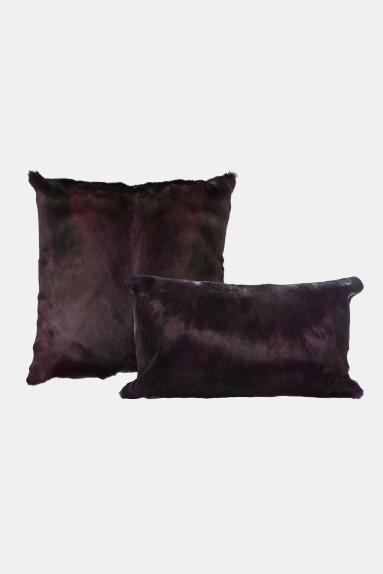 Two dark purple pillows on a white background