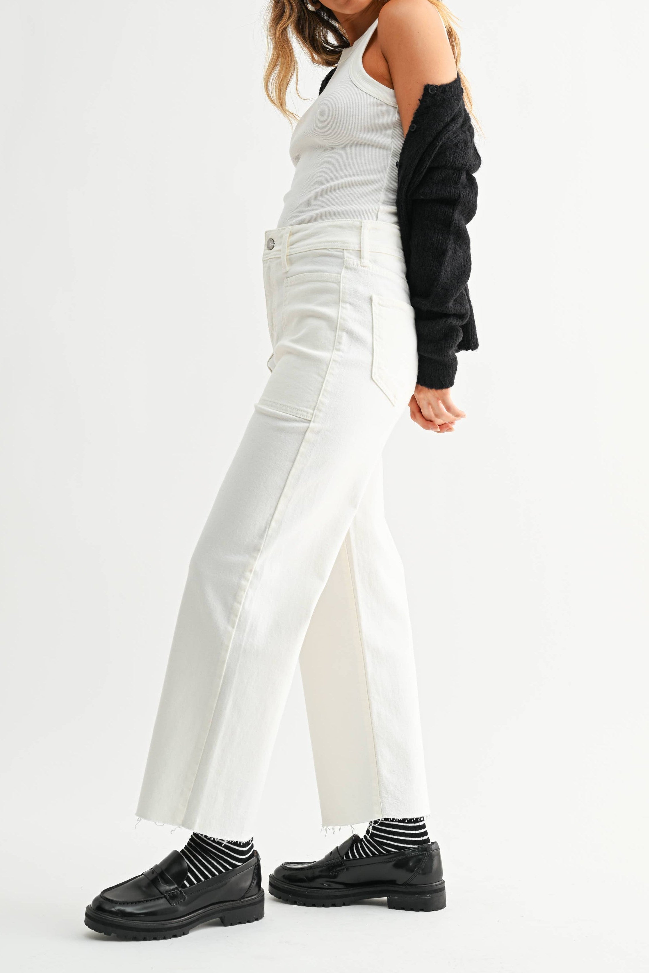 Woman wearing a white outfit with black sleeves on a white background
