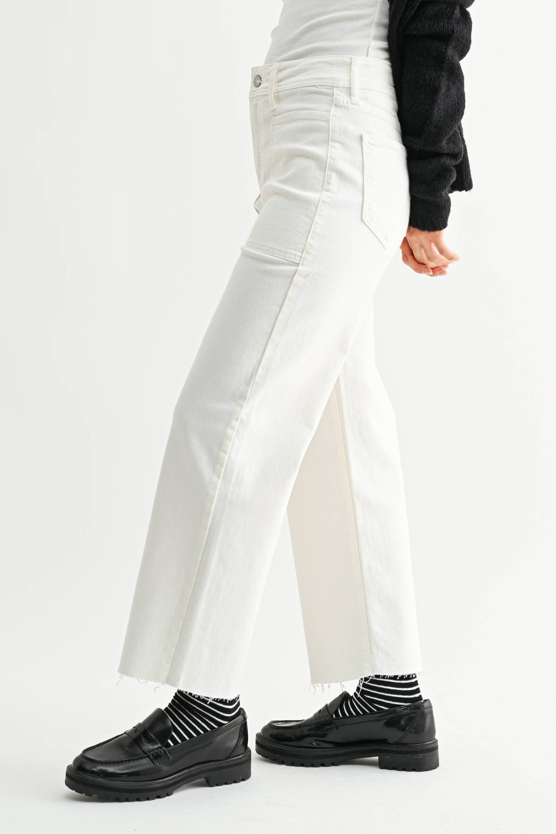 Woman wearing a white outfit with black sleeves on a white background