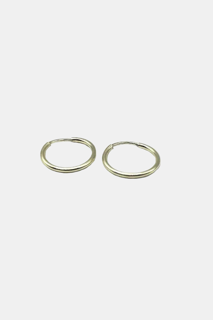 Two gold hoop earrings on a white background