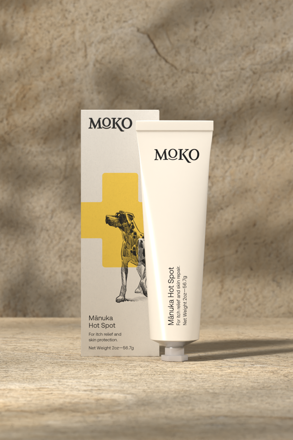 MOKO Manuka Hot Spot cream and packaging on a wooden surface with a stone wall background
