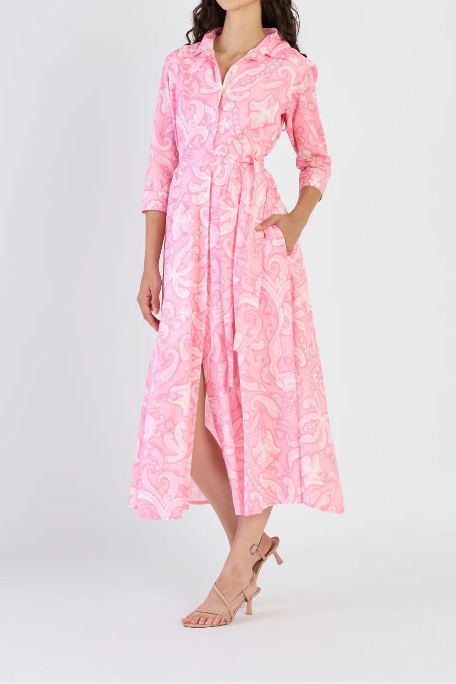 Woman wearing a pink dress with a floral pattern on a white background