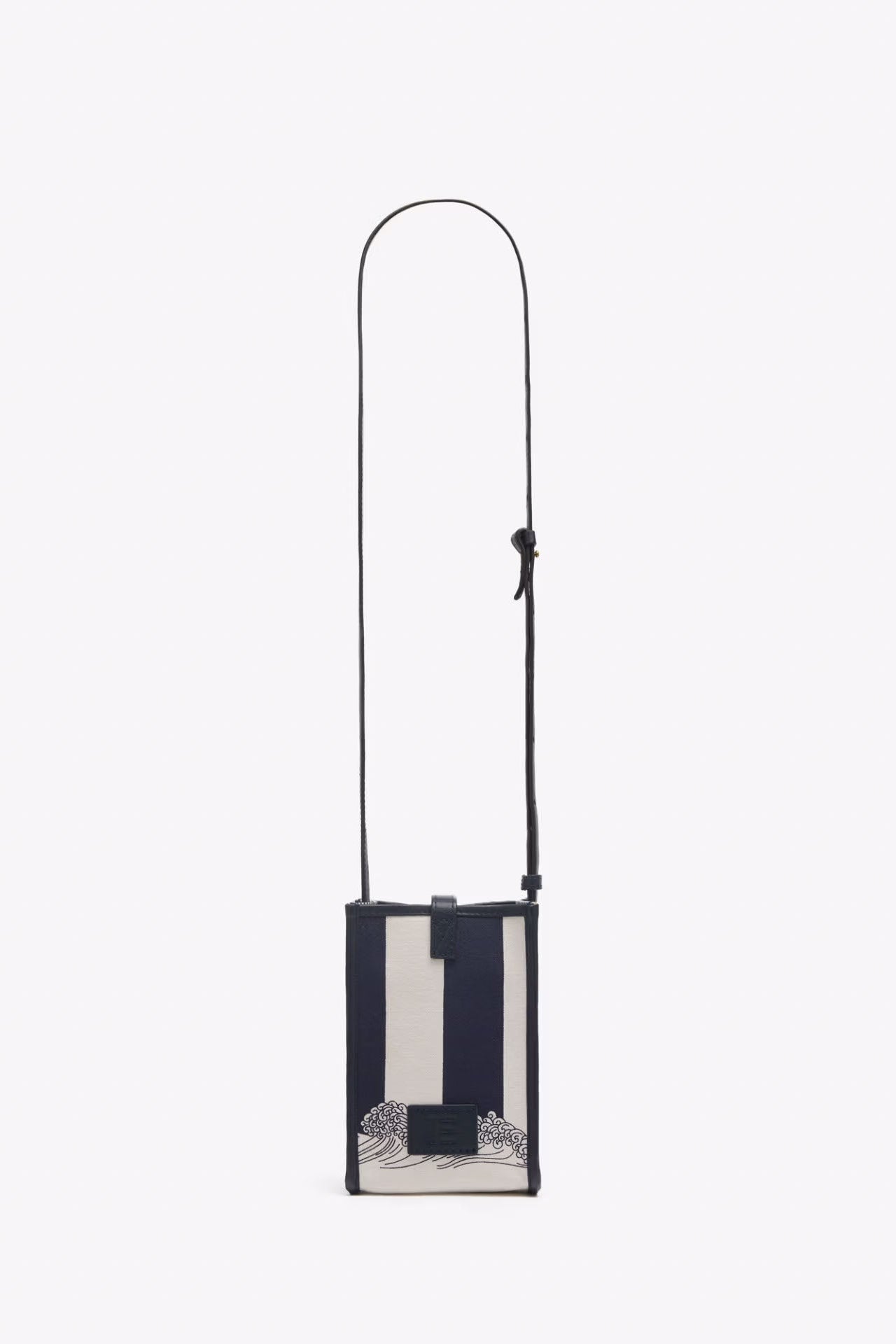 A vertical rectangular crossbody bag with a navy and off-white striped pattern, featuring a black adjustable shoulder strap and a small black logo plaque at the top center.