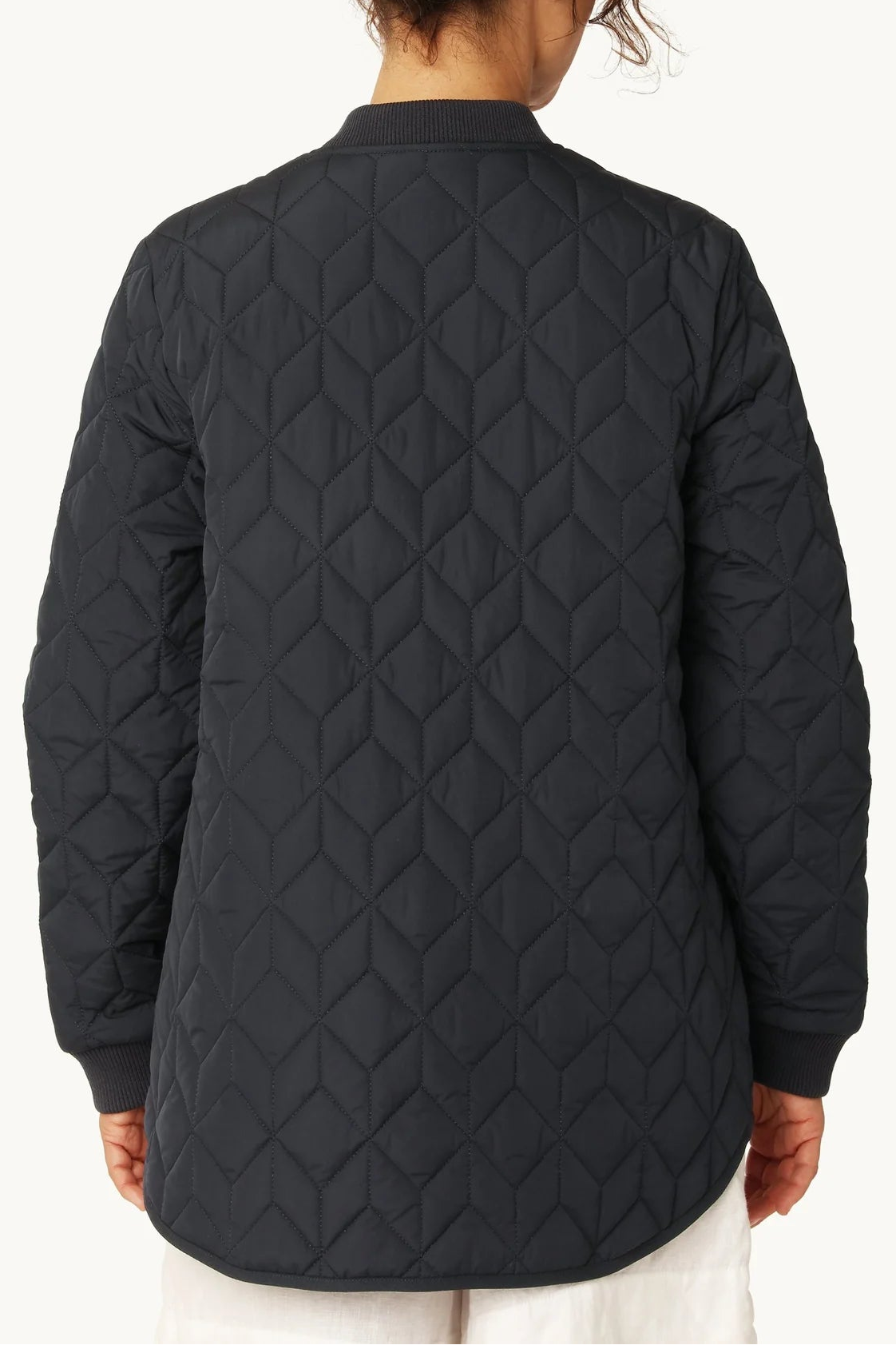 Person wearing a black quilted jacket on a white background