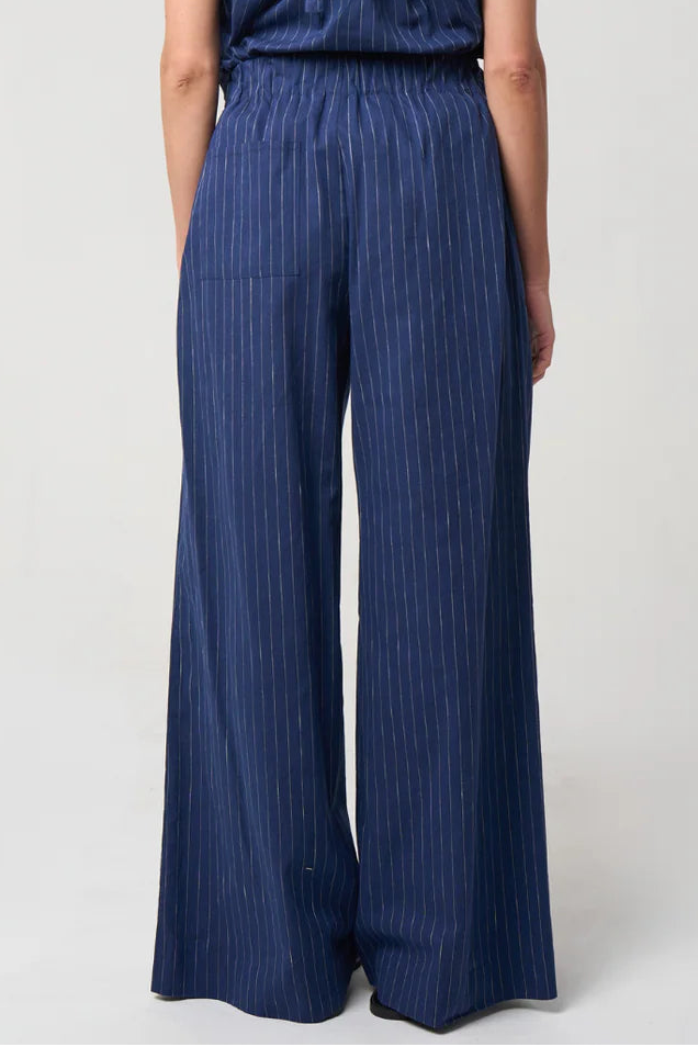 Woman wearing a blue striped jumpsuit on a white background