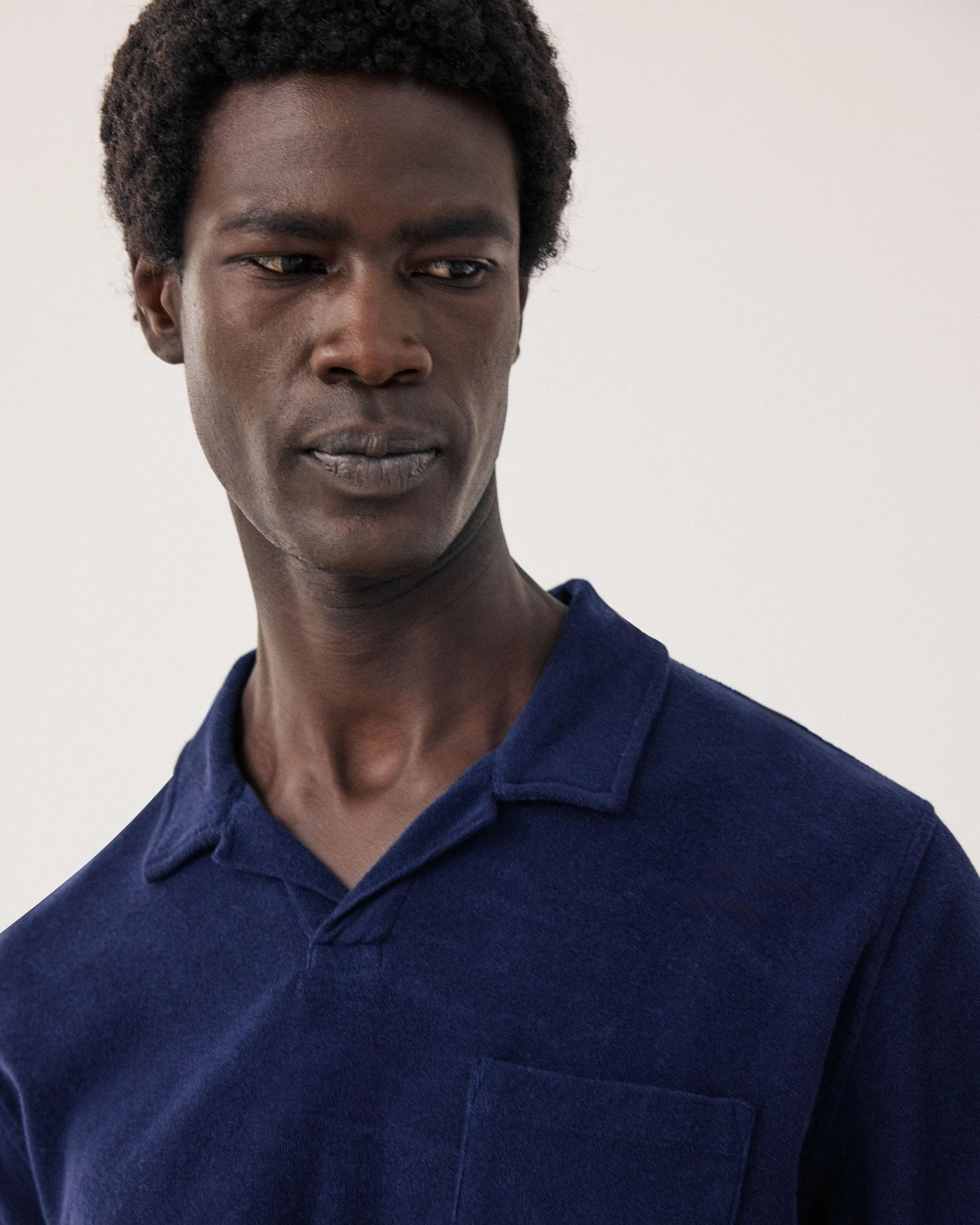 Man wearing a blue polo shirt against a plain background