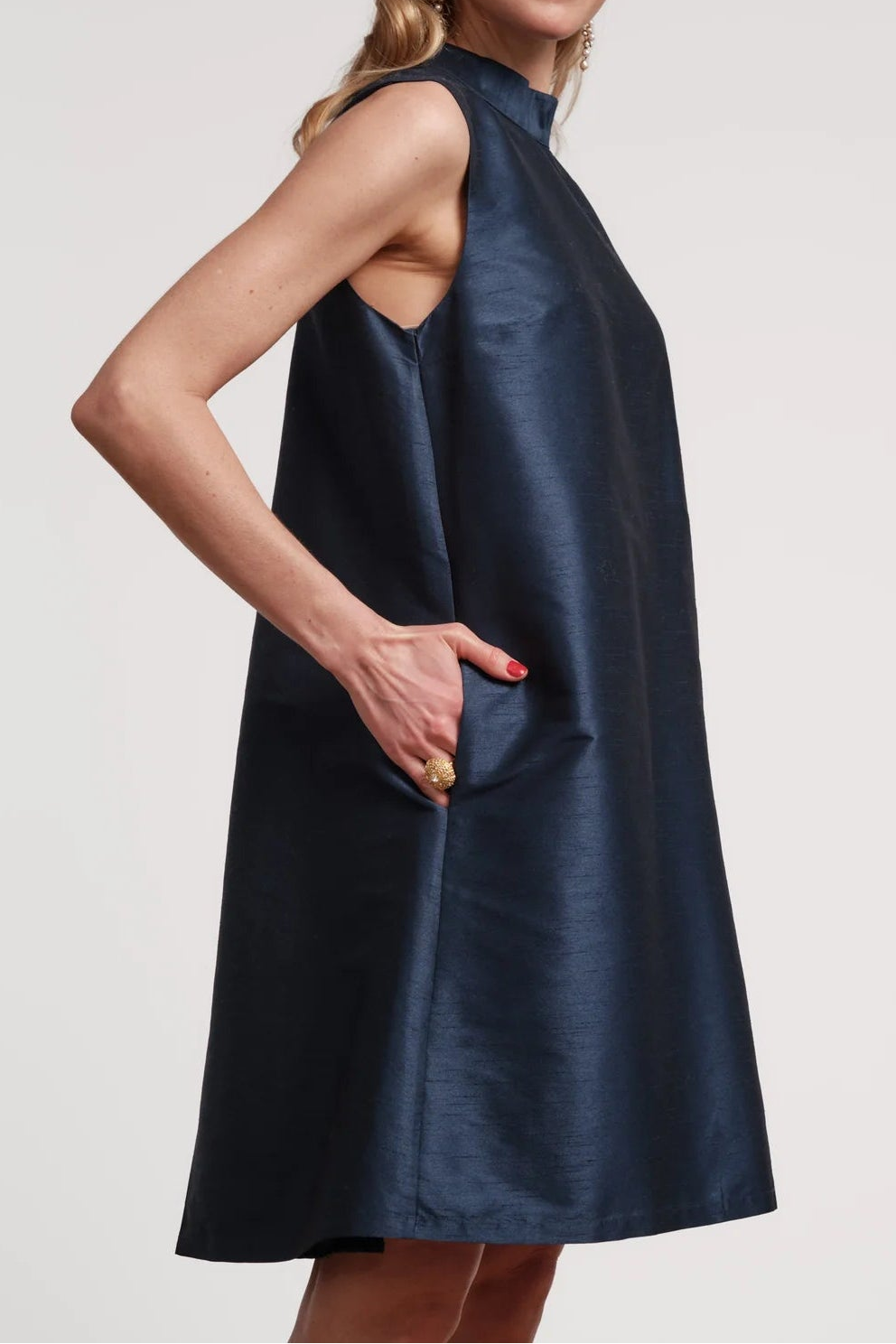 Woman wearing a navy blue dress against a plain background
