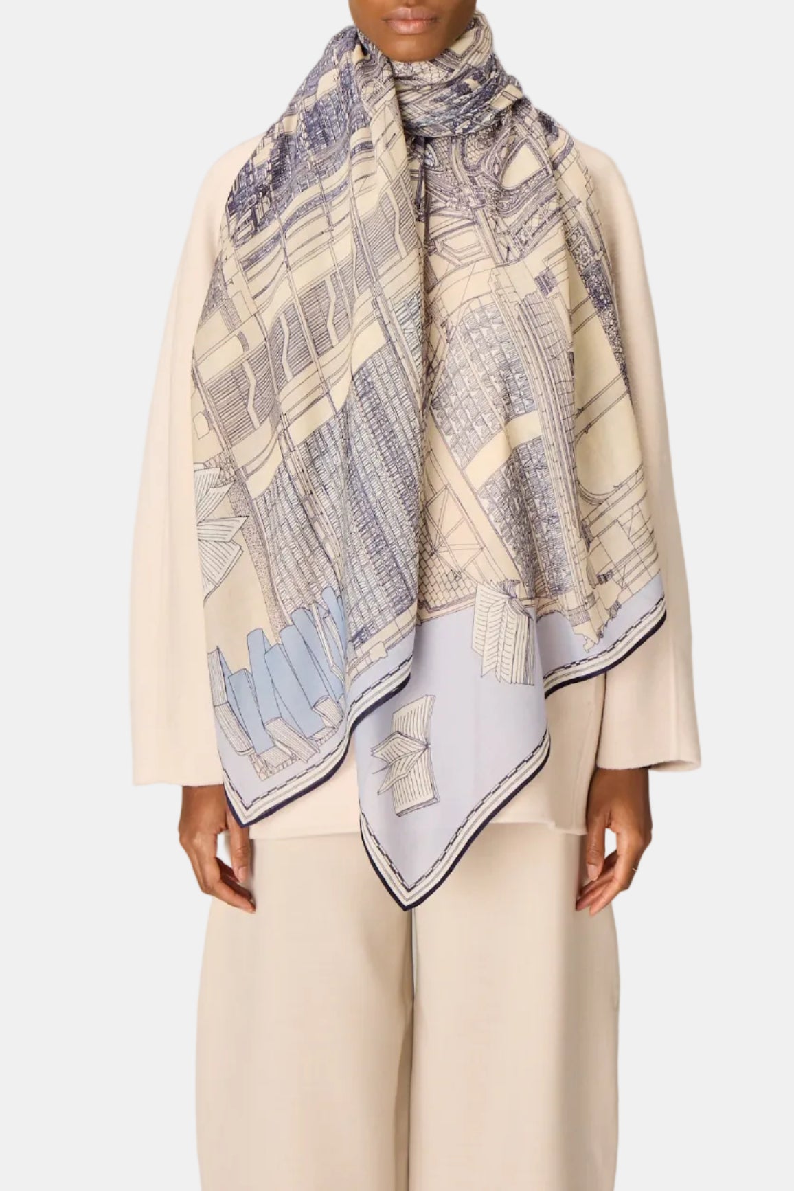 Woman wearing a patterned scarf on a plain background