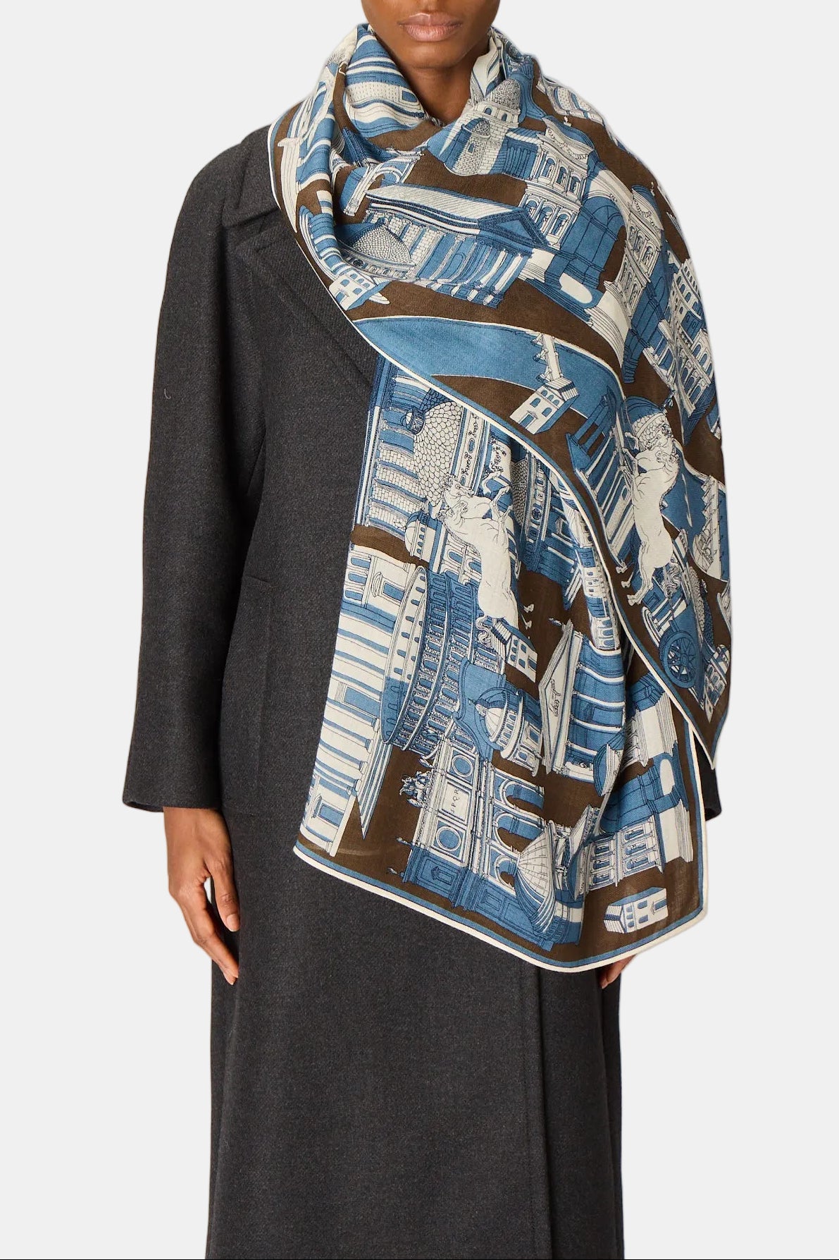 Person wearing a patterned scarf on a plain background