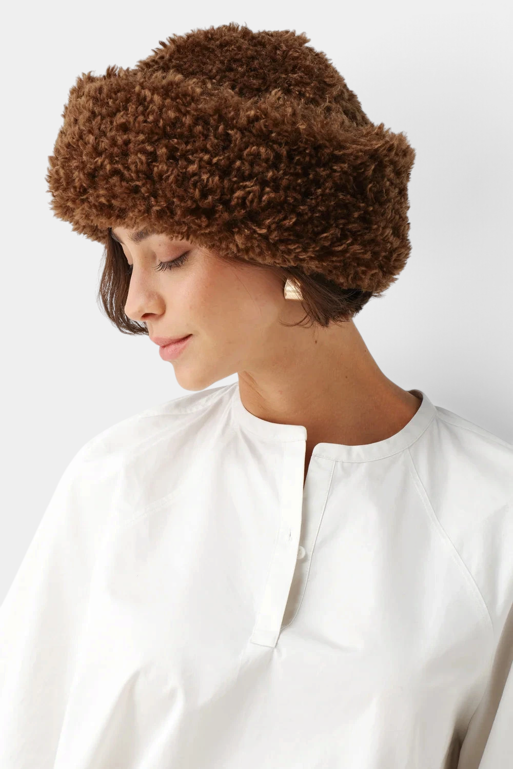 The Copper Shed brown faux sheepskin sherpa hat with a deep brim worn by a woman.