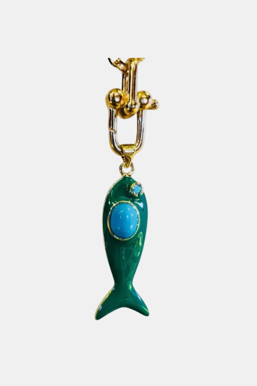 Green fish-shaped keychain with blue stone on a gold chain against a white background