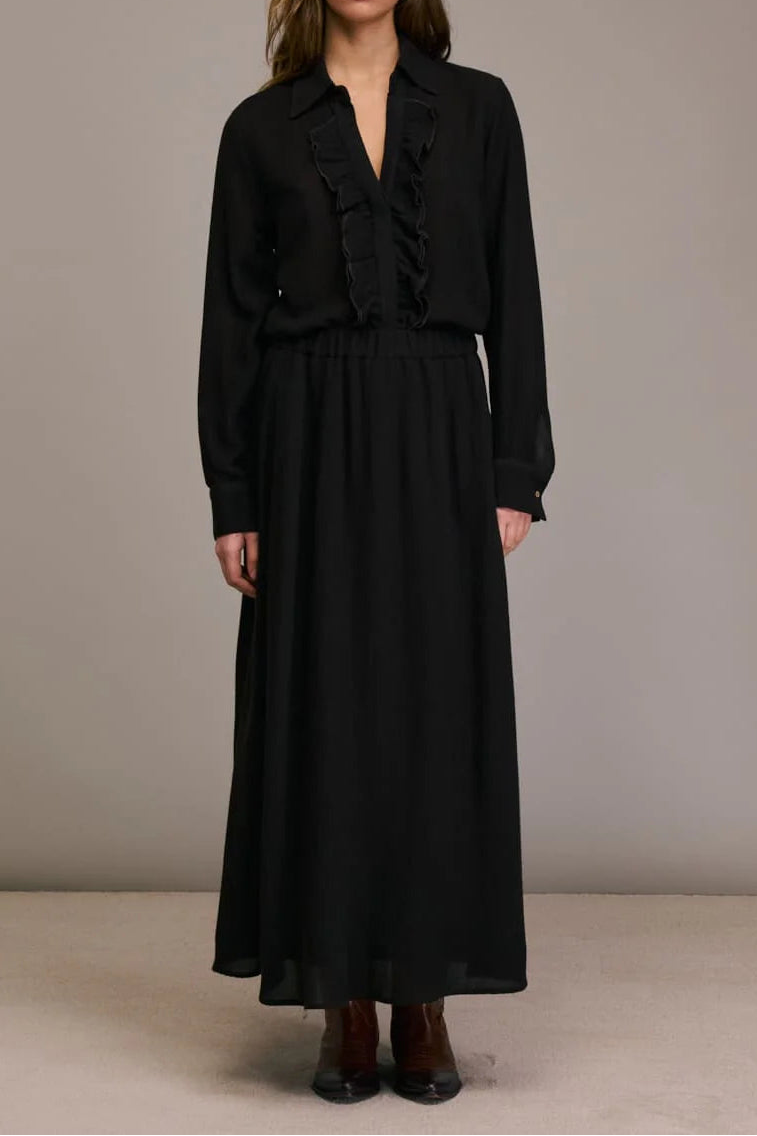 Woman wearing a black outfit against a plain background