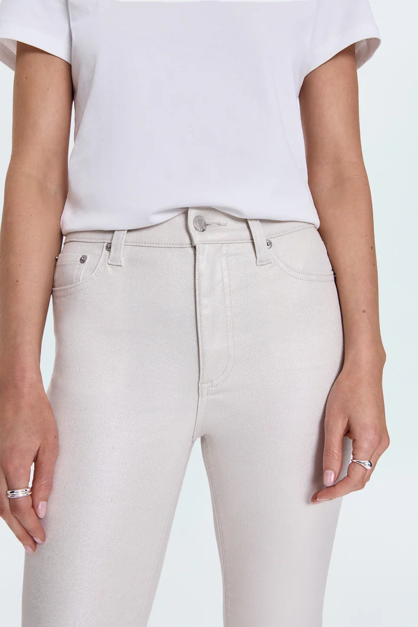 Person wearing light gray jeans and a white top on a light blue background