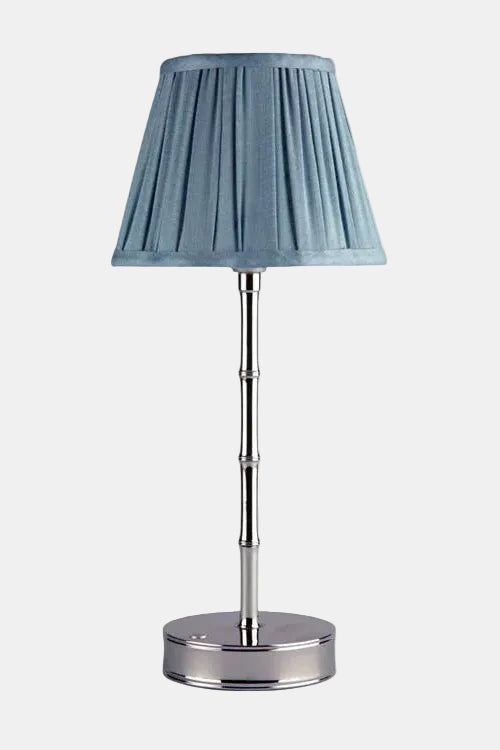 Table lamp with a blue pleated shade on a white background