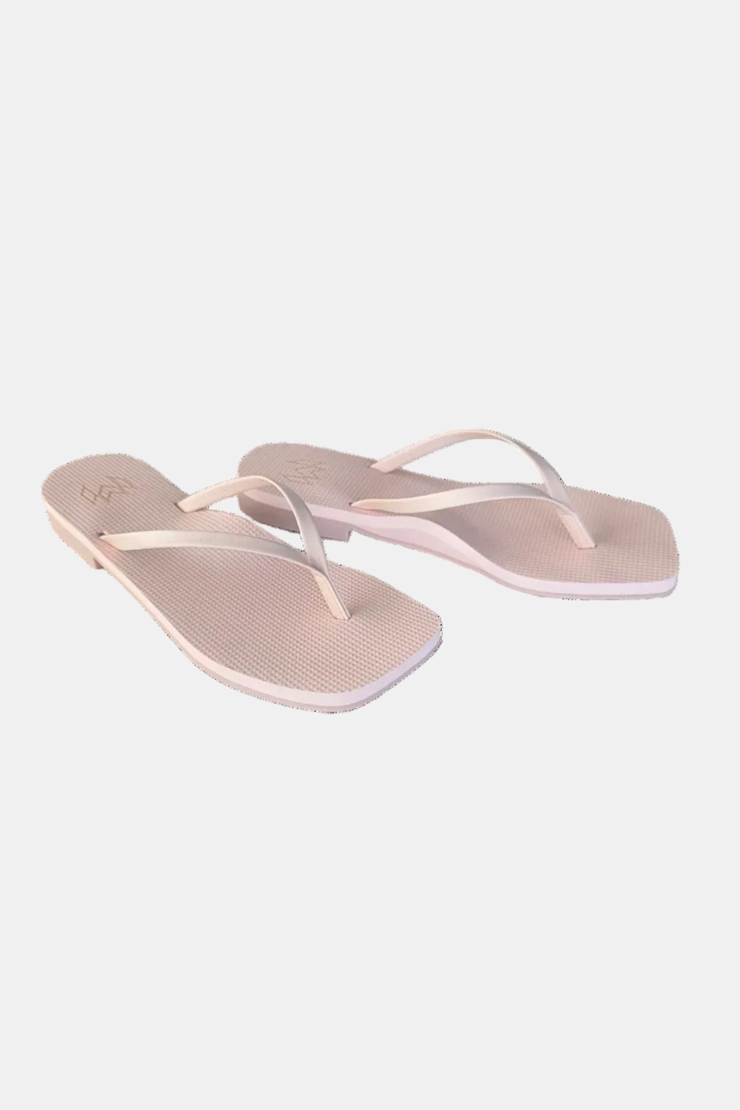 Pair of beige flip-flops with white straps on a white background