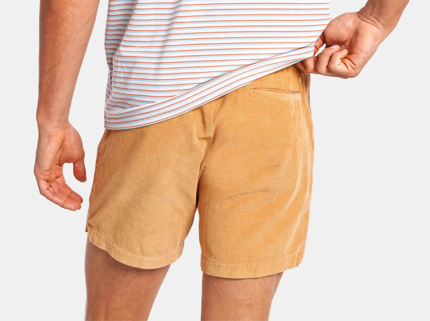 Person wearing tan shorts and a striped shirt on a white background