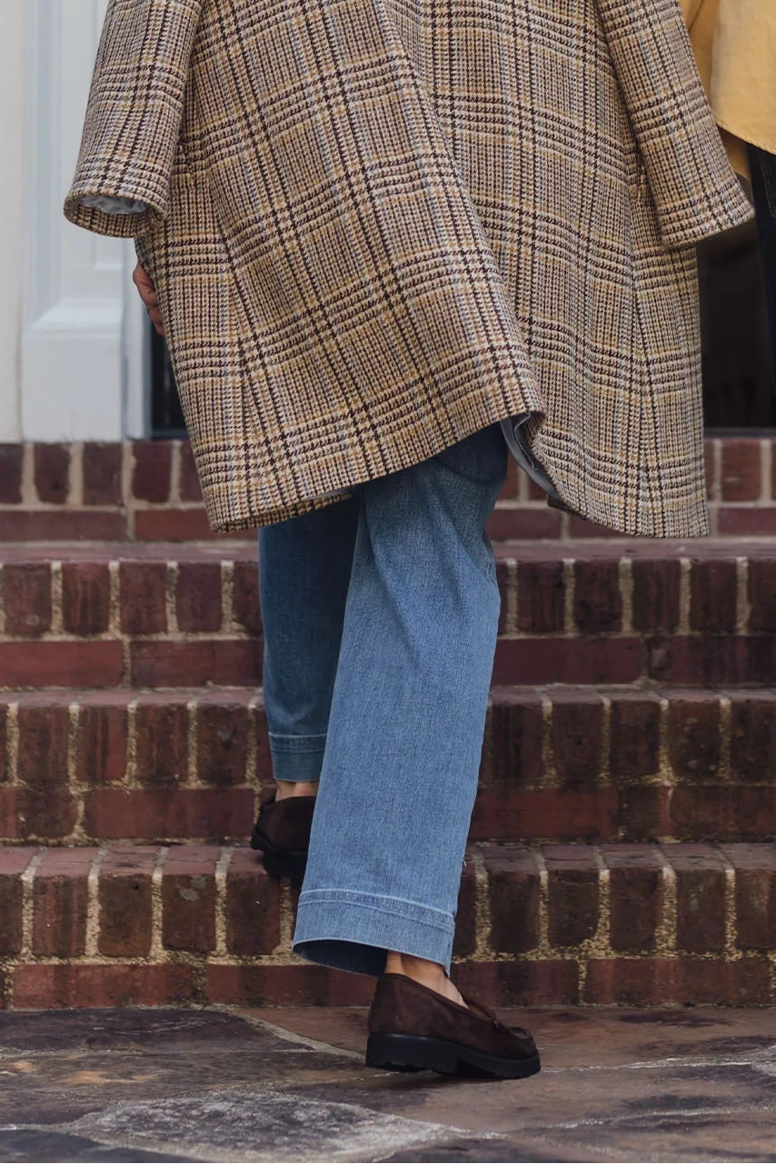 Two people walking up a set of stairs, one in a plaid coat and the other in a yellow jacket.