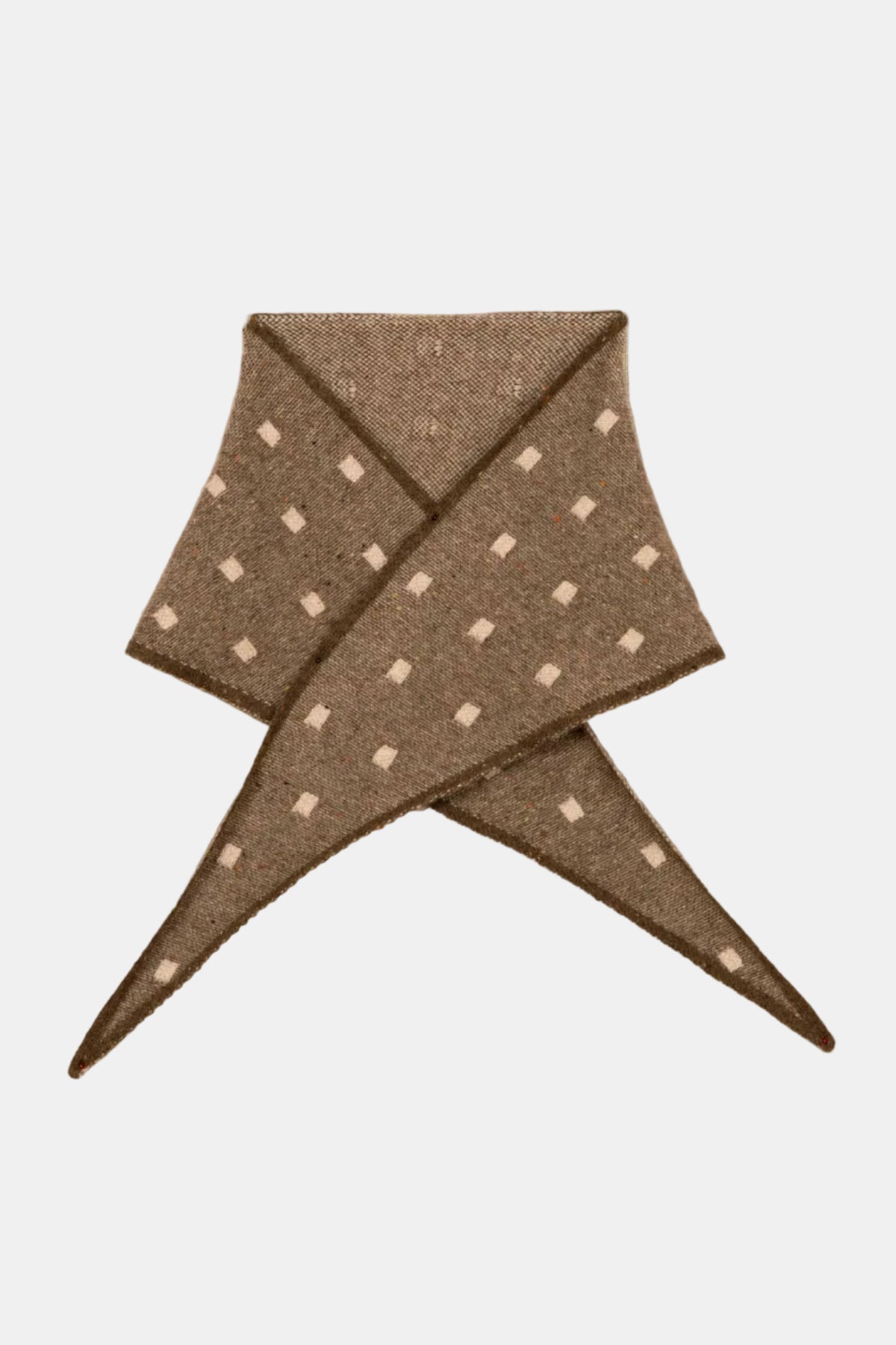 Brown fabric with white polka dots folded into a triangle shape on a beige background
