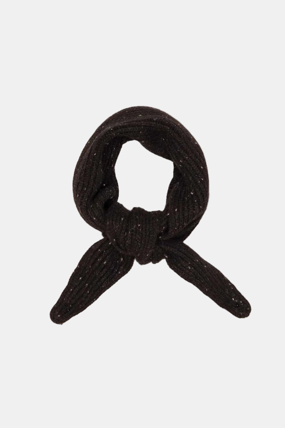 A small black knotted fabric accessory, possibly a miniature scarf, tie, or decorative knot, displayed on a textured off-white fabric background.