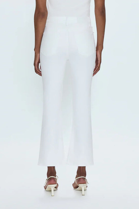 Woman wearing a white sleeveless dress on a plain background