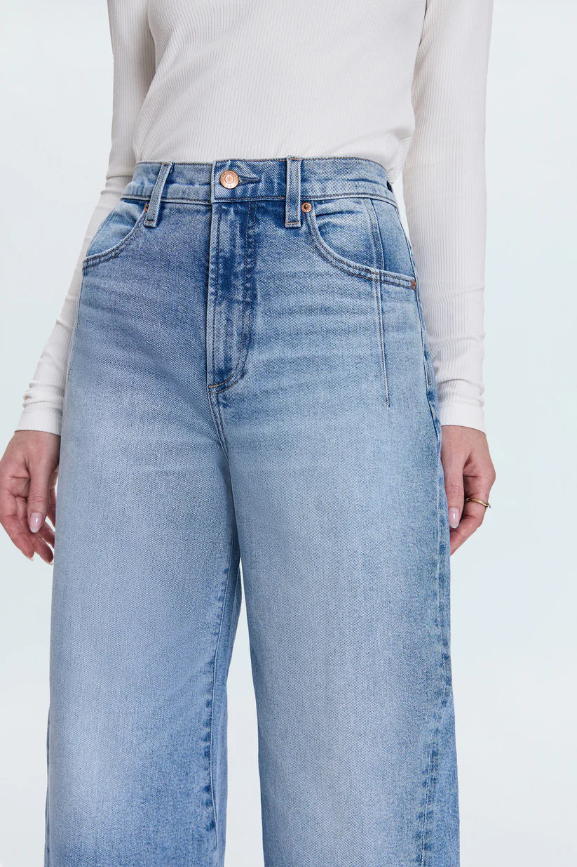 Light blue jeans worn by a person on a white background