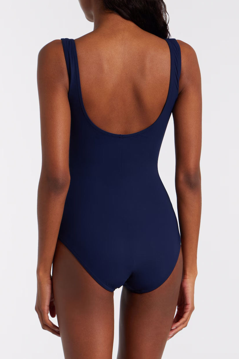 Navy blue swimsuit on a model against a light gray background