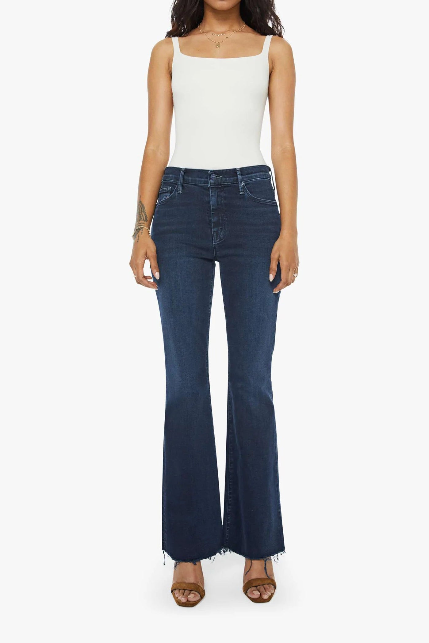 Woman wearing blue jeans and a white top on a white background