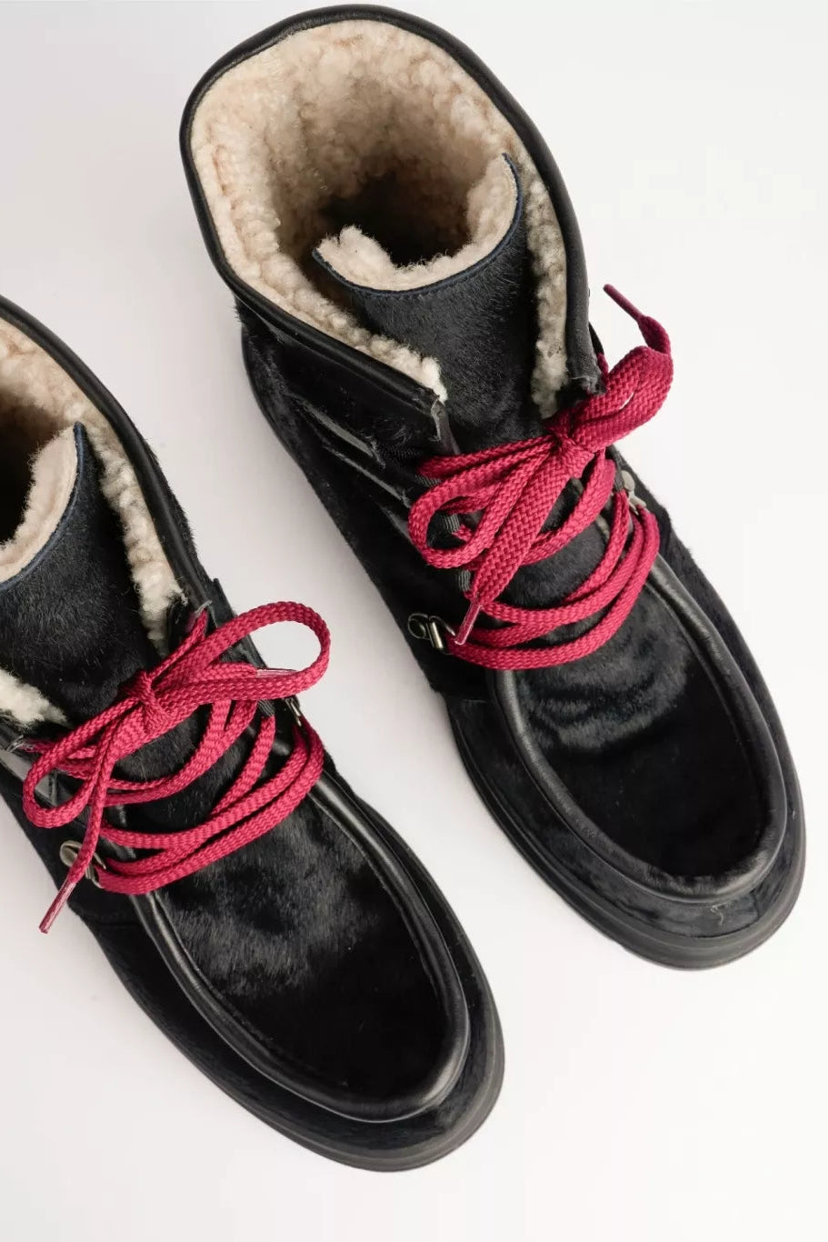 Black boots with red laces on a white background
