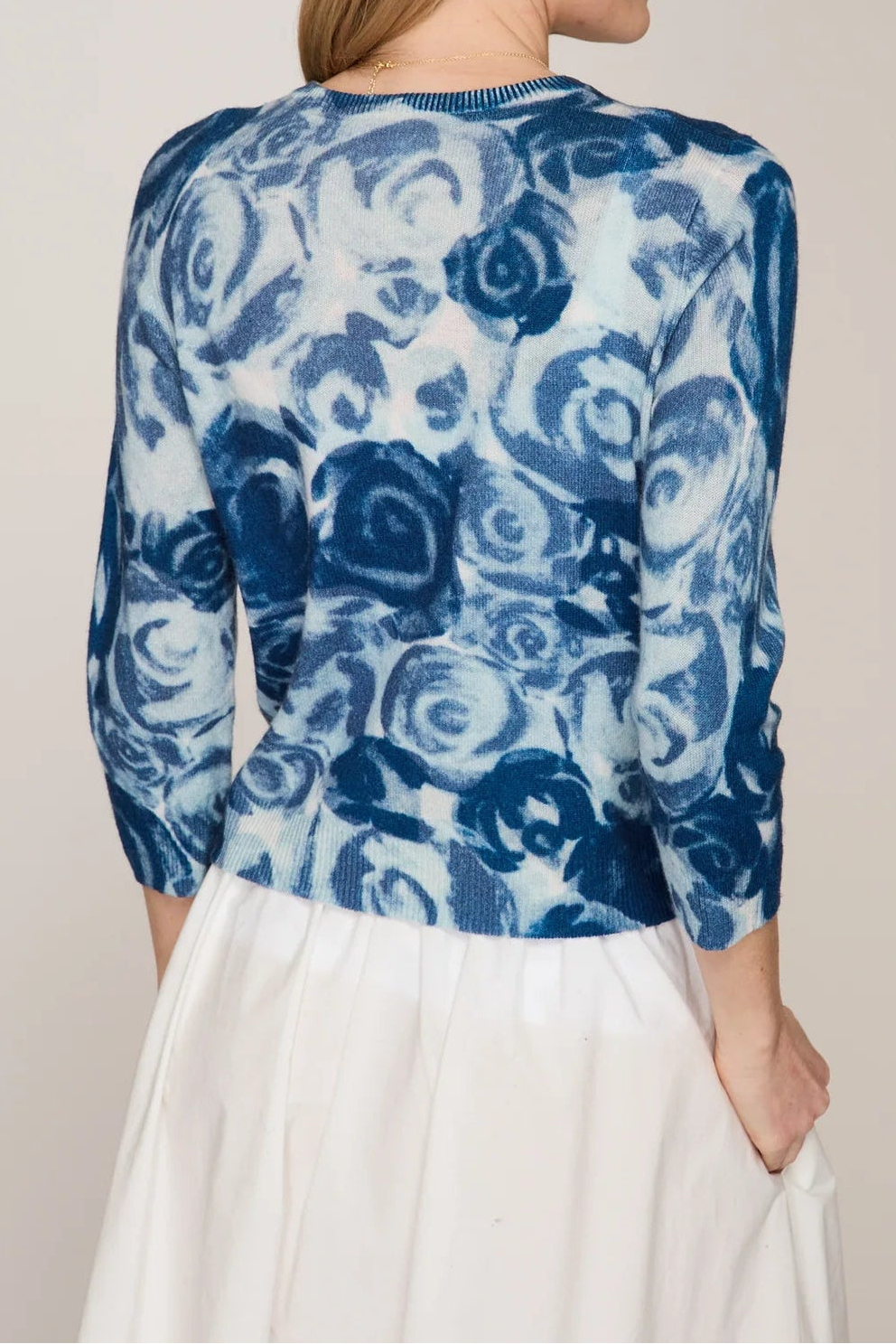 Woman wearing a blue floral patterned top with a plain background
